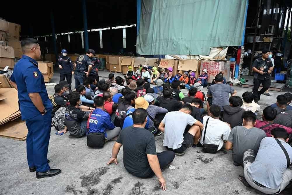 Sebahagian pekerja warga asing yang ditahan di kilang kitar semula sisa elektronik haram di Jalan Klang-Kuala Selangor, di sini pada Rabu.
