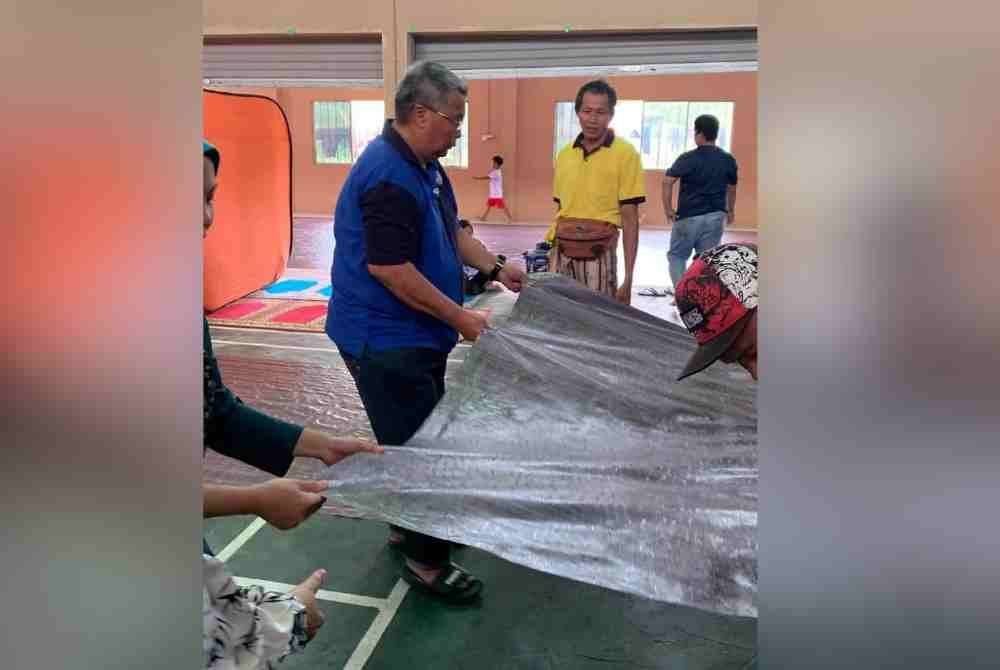 Awang Aslee ketika turun padang membantu mangsa banjir yang ditempatkan di pusat pemindahan sementara di Beaufort.