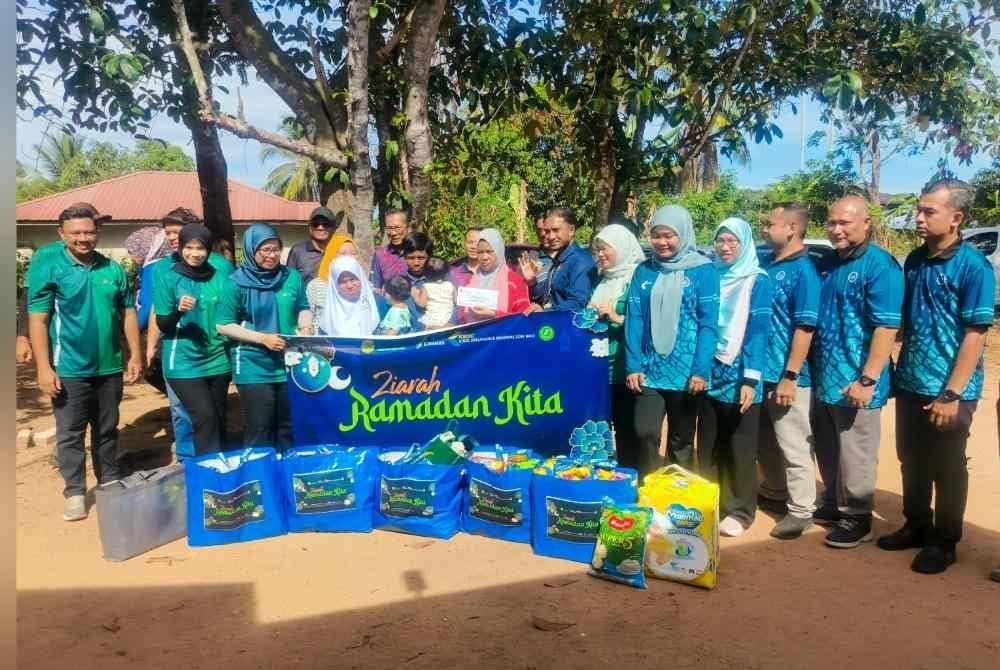 Zuraina (kanan) bersama empat anak saudara menerima sumbangan Program Ziarah Ramadan Kita di Telok Jamat, Alor Setar pada Rabu.