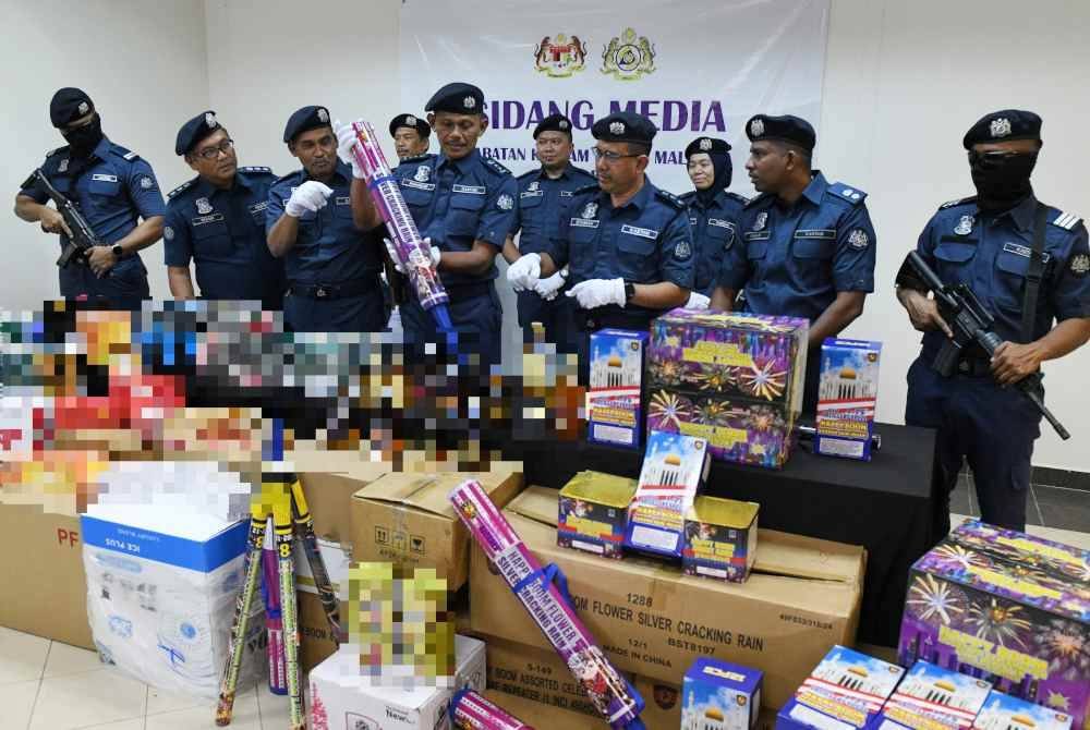 Rohaizad (empat, kanan), menunjukkan pelbagai jenis mercun yang dirampas dalam satu sidang akhbar mengenai rampasan minuman keras, rokok pelbagai jenama, serta mercun dan bunga api di Stor Penguatkuasaan Jabatan Kastam Pulau Pinang pada Rabu. Foto Bernama