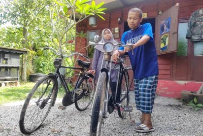 Mohamad Nasirudin menunjukkan koleksi basikal tua miliknya yang masih disimpan di rumahnya di Kampung Jambatan Duyong.