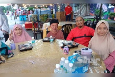 Napisah (kiri) dan Mat Hussain (dua dari kiri) bersama keluarga mereka.