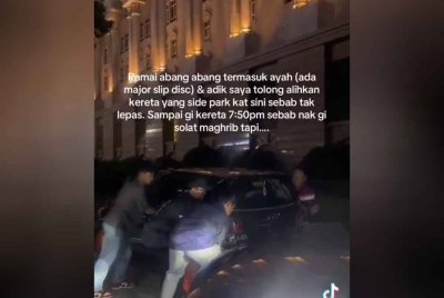 Sebuah kereta yang diparkir secara bertindih terpaksa dialihkan beramai-ramai bagi membolehkan kenderaan pengguna yang terhalang meneruskan urusan masing -masing.