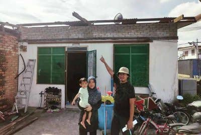 Mohd Nor Fadli dan isterinya menunjukkan garaj kereta musnah dalam kejadian ribut pada Selasa.