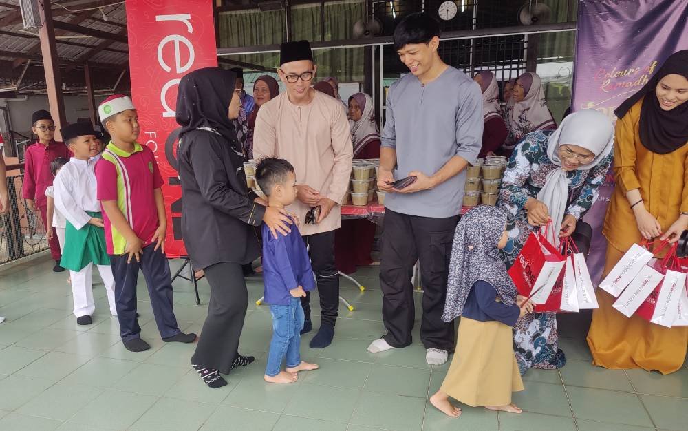 Jemay (empat dari kanan) dan Uncle Tokok (tiga dari kanan) menyerahkan sumbangan duit raya kepada kanak-kanak.