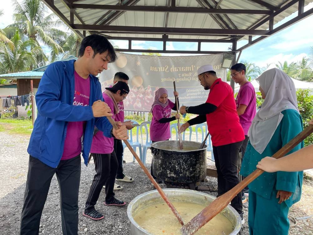 Sebahagian kakitangan redONE Mobile dan komuniti setempat bersama-sama memasak serta menyediakan bubur lambuk.