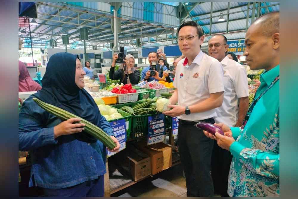 Ting Han (tengah) meninjau Pasar Awam Perling pada pagi Khamis