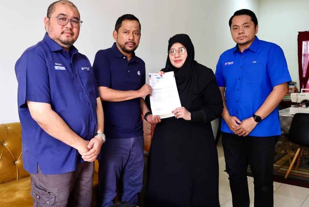 Simbolik penyerahan wang pampasan perlindungan takaful oleh Syaiful Rizal (dua dari kiri) kepada Noor Azizah (dua dari kanan).