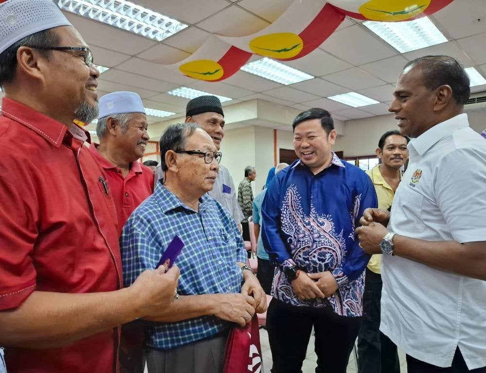Saravanan (kanan) menyantuni jawatankuasa masjid dan surau yang menerima agihan sumbangan dalam majlis pada Khamis.