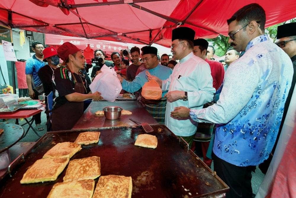 Perdana Menteri, Datuk Seri Anwar Ibrahim (dua, kanan) beramah mesra bersama peniaga ketika hadir membuat lawatan ke Bazar Ramadan Seksyen 2 Shah Alam pada Khamis. Foto Bernama