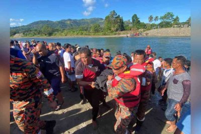 Pasukan bomba dan penduduk kampung membawa naik mayat lelaki yang ditemukan di Sungai Kampung Pirasan, Kota Belud.