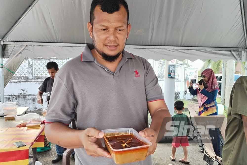 Mohd Azizul menunjukkan gulai kawah yang dijual pada harga RM10 sebekas.
