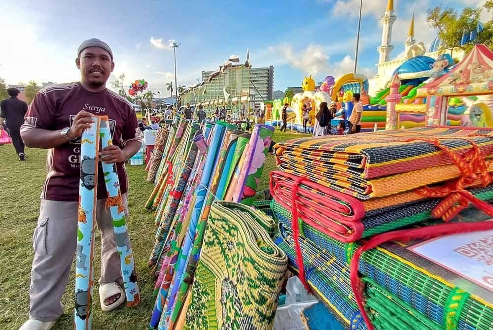 Mohd Syafiq menunjukkan salah satu tikar yang sering menjadi permintaan pelanggannya. Foto Sinar Harian.
