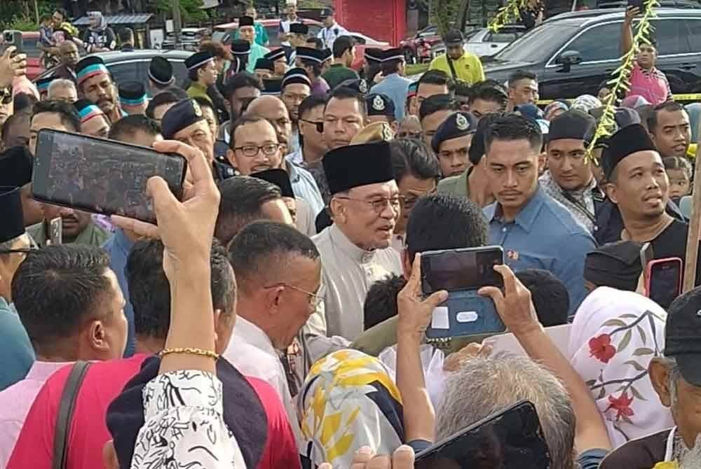 Anwar dikerumui orang ramai sejurus tiba di Bazar Ramadan Rahmah Kamunting, di Taiping pada Jumaat.