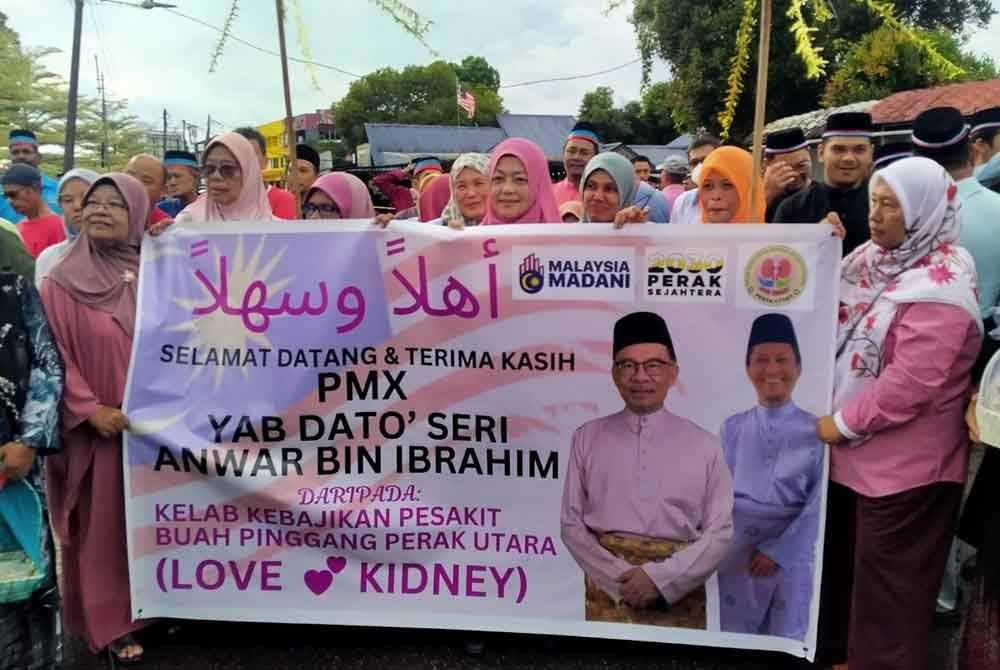 Kehadiran Anwar disambut ahli Kelab Kebajikan Pesakit Buah Pinggang Perak Utara dengan membawa bunga manggar.