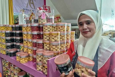 Noraliza menunjukkan kuih raya yang dijual tujuh balang pada harga RM100.