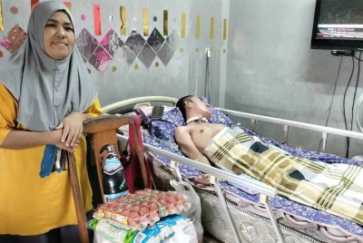 Shapidah setia menjaga Mohd Zaki yang terlantar selepas terlibat dalam kemalangan motosikal di kediamannya di Taman Orkid, Kluang.