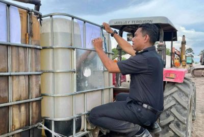 Pegawai penguat kuasa KPDN Perak memeriksa tangki yang mengandungi cecair dipercayai minyak diesel bersubsidi dalam Ops Tiris 2025 di sebuah premis di Pantai Remis pada Khamis.