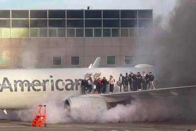 Penumpang berdiri di atas sayap pesawat American Airlines ketika mereka dipindahkan selepas pesawat itu terbakar di pintu masuk Lapangan Terbang Antarabangsa Denver, Colorado. - AFP