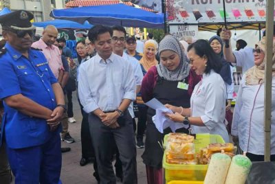 Maria (dua dari kiri) menerangkan kepada peniaga bazar mengenai keselamatan makanan ketika melakukan tinjauan mesra di Bazar Ramadan Lintasan Deasoka, Kota Kinabalu.