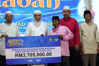 Ahmad Zahid menyampaikan sumbangan cek cura Program Pembangunan Risda Negeri Perlis kepada wakil penerima pada Majlis Santuni Kasih Ramadan KKDW 2025 di UiTM Arau di sini malam ini - Foto: Bernama