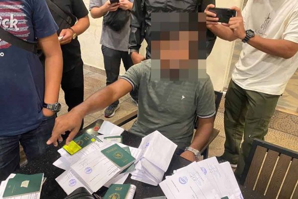 Seorang ejen haram warga asing menjelaskan sesuatu kepada pegawai JIM yang menyerbu empat lokasi sekitar Kuala Lumpur dan tiga lokasi di Bandar Bukit Raja,Selangor pada Rabu dan Khamis. Foto: JIM.