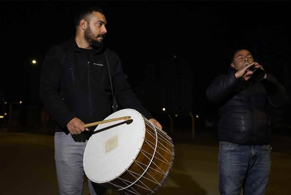 Pemukul gendang tradisional Ramadan memainkan irama untuk membangunkan penduduk bersahur di daerah Mamak, Ankara. Foto Xinhua