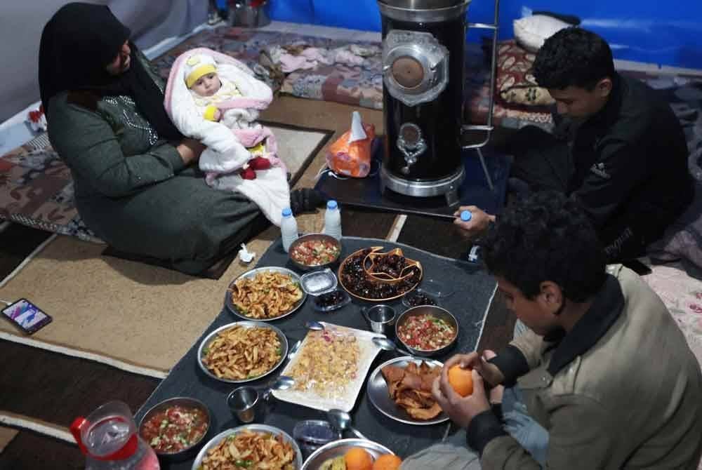 Sebuah keluarga sedang menikmati juadah bersahur. Foto AFP