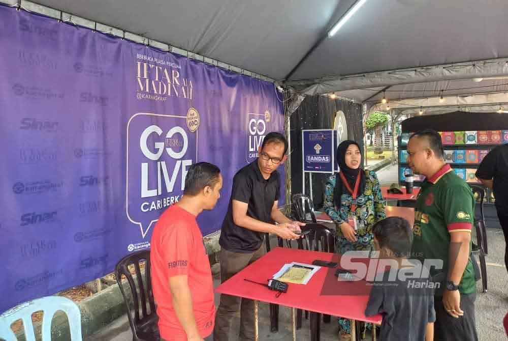 Orang ramai mengimbas kod QR sebelum menyertai Iftar Ala Madinah @Karangkraf.