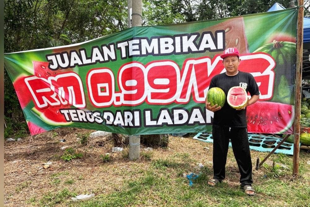 Aizuddin menunjukkan buah tembikai yang dijual di gerainya.