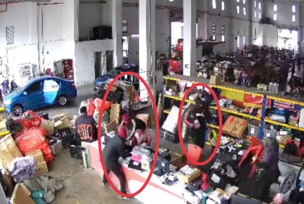 Tangkap layar video tular yang memaparkan suspek mengacu parang kepada petugas di hub syarikat penghantaran berkenaan di Meru, Klang pada Jumaat.