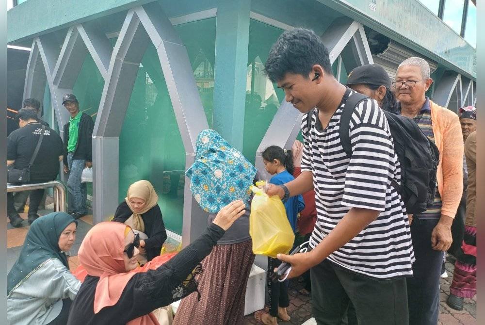 Penerima beratur bagi mendapatkan juadah berbuka puasa di lokasi agihan juadah di hentian bas pokok Buluh berhampiran Mahkota Square di sini padaJumaat.