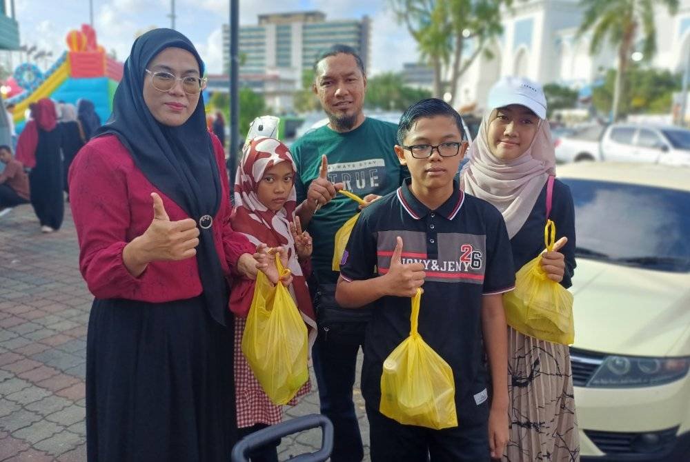 Norisis bersama ahli keluarga turut menerima juadah berbuka percuma di lokasi agihan juadah di hentian bas pokok Buluh berhampiran Mahkota Square di sini pada Jumaat.