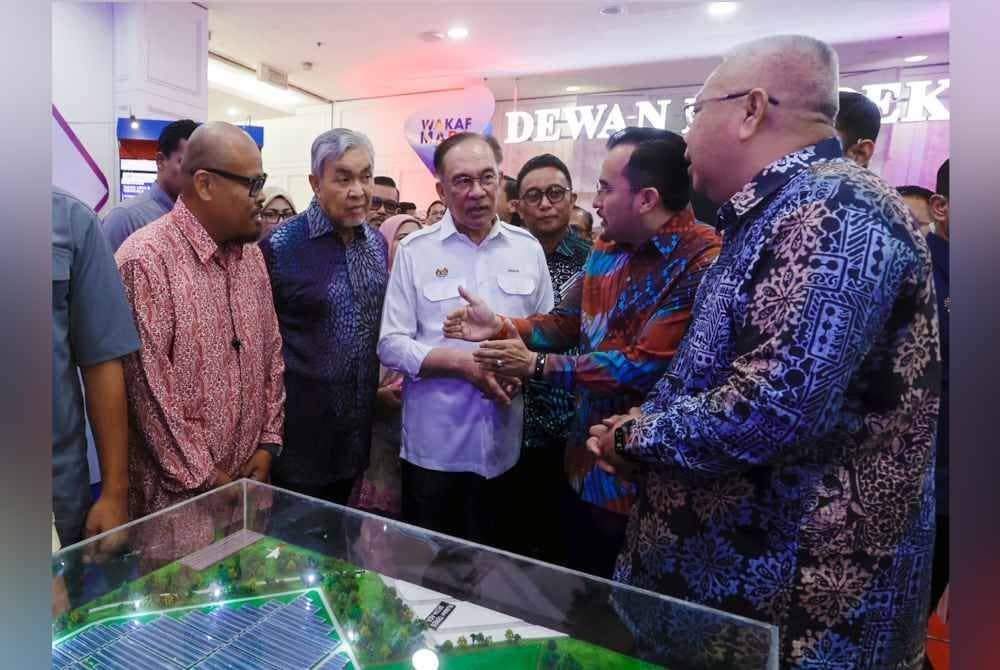 Anwar (tengah) melawat tapak pameran pada Majlis Peluncuran Wakaf Mara Madani sempena Sambutan Hari Mara Ke-59 di Pusat Dagangan Antarabangsa Kuala Lumpur pada Sabtu. Foto Bernama