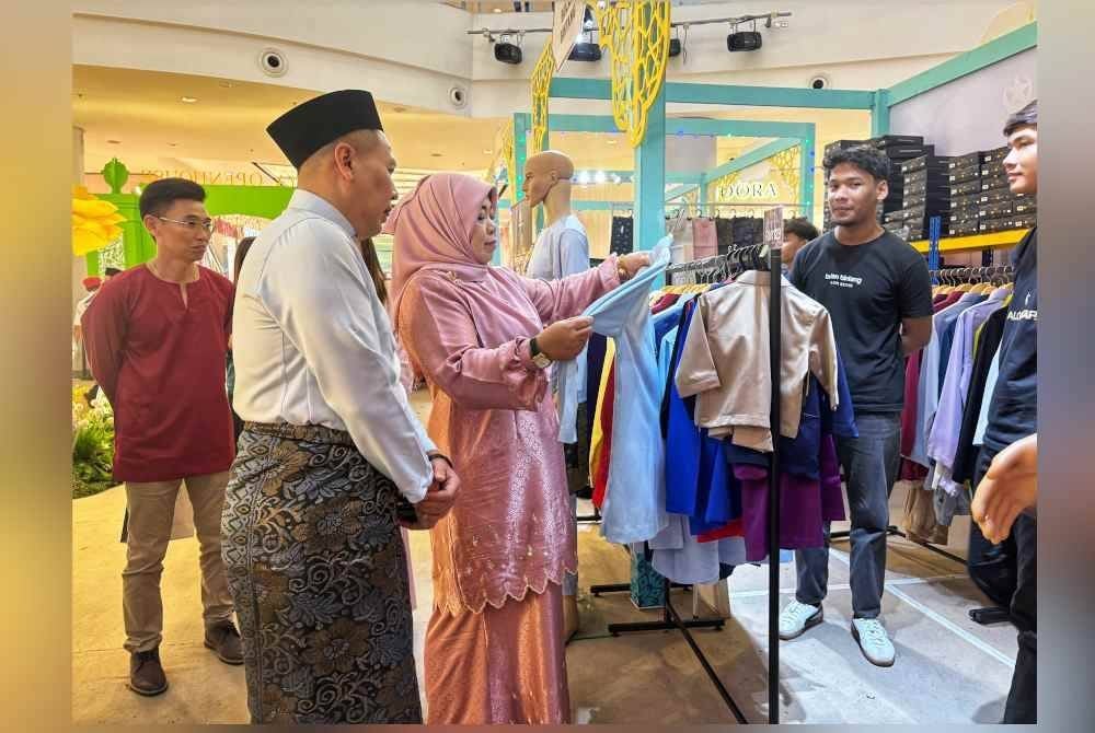 Halimaton Shaadiah sedang melihat baju melayu yang diperagakan di reruai Bulan Bintang di Aman Central di sini pada Jumaat.