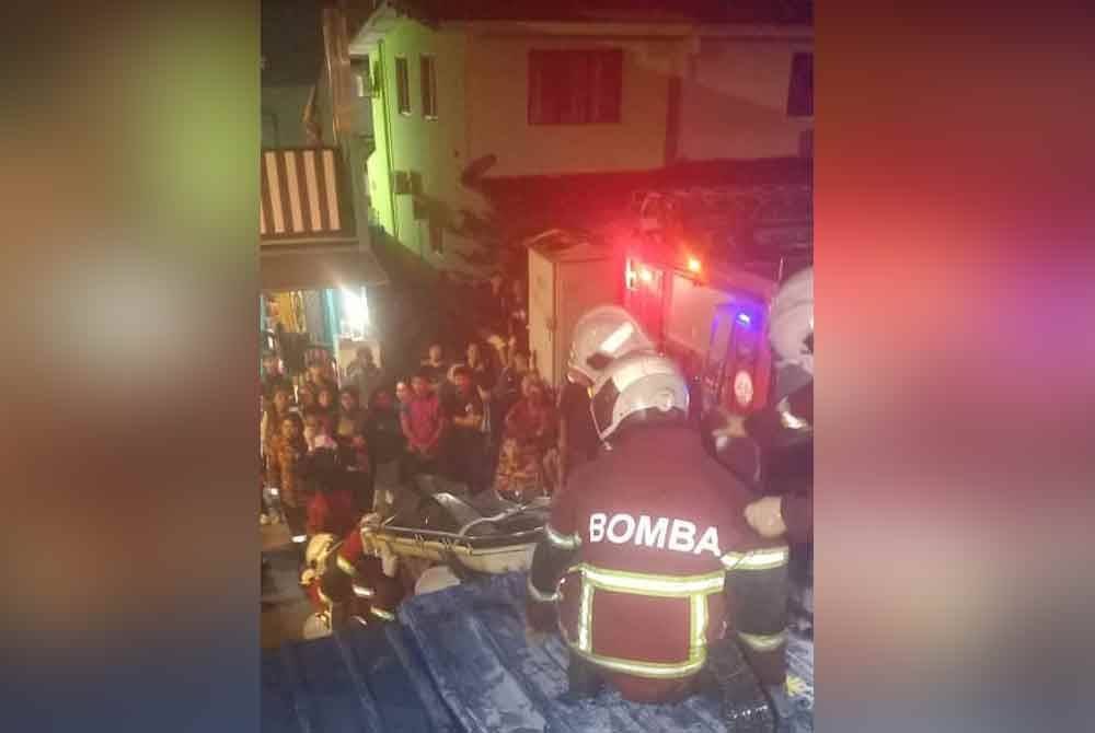 Anggota bomba berusaha memadamkan kebakaran rumah berkenaan.