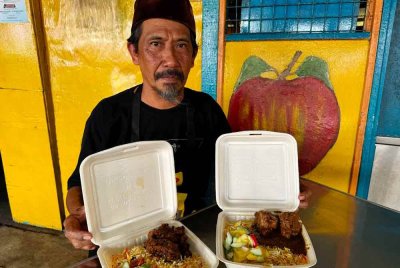 Basir menunjukkan nasi yang dijualnya di bazar Ramadan Pekan Parit Betak, di Pontian. Foto Bernama