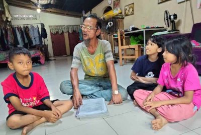 Abdul Hadi (dua dari kiri) bersama tiga anak saudaranya yang kini tinggal bersama selepas ibu mereka meninggal dunia.