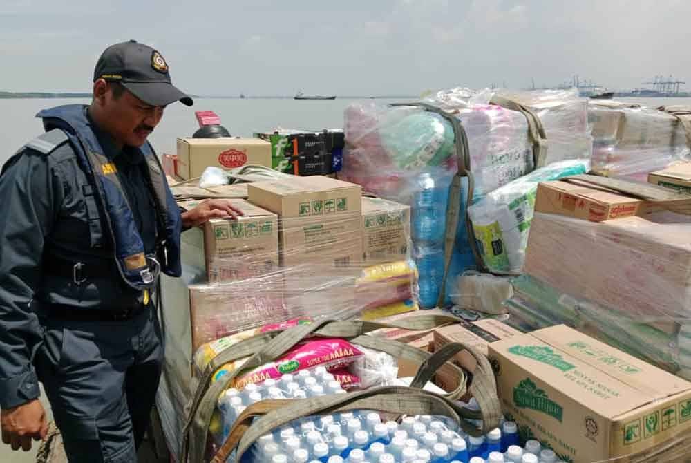 Pegawai KPDN menjalankan pemeriksaan melibatkan dokumen serta barangan termasuk barangan kawalan di sebuah bot yang ditahan.