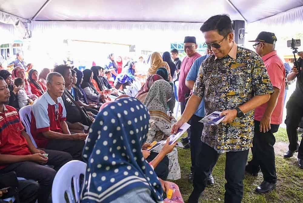 Jalaluddin (dua dari kanan) menyampaikan sumbangan kepada penerima pada Bantuan Aspirasi Warga Emas dan Asnaf DUN Sungai Lui pada Ahad. Foto Facebook Jalaluddin Alias