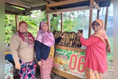 Bainah (kanan) bersama anak, cucu yang mewarisi resipi lemangnya yang dijual di Kampung Lepan Jenut, Kuala Krai.