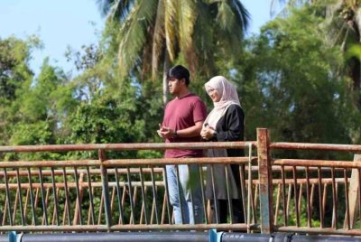 Suraiya Izzaty Sabari, 30, ditemani suaminya menziarahi lokasi jasad Allahyarham bapanya dicampak ke dalam Sungai Padang Terap. - Foto Bernama