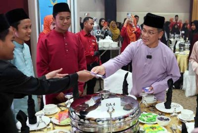 Mohd Na'im Mokhtar menyampaikan sumbangan Aidilfitri kepada anak-anak yatim Pertubuhan Kebajikan Anak- anak Yatim dan Miskin Darul Akhyar, Batu Rakit pada Majlis Berbuka Puasa dan Penjenamaan Semula Hotel Wakaf The Grand Puteri Terengganu, hari ini. Foto Bernama