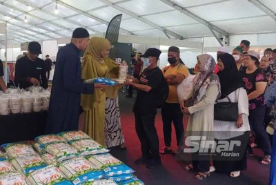 Riza Che Umar (dua dari kiri) menyampaikan sumbangan beras, nasi Arab dan bubur lambuk kepada pengunjung Karnival Warisan @ Saloma Ramadan Raya di ibu negara, pada Ahad - Foto Sinar Harian/MOHD FAIZUL HAIKA MAT KHAZI
