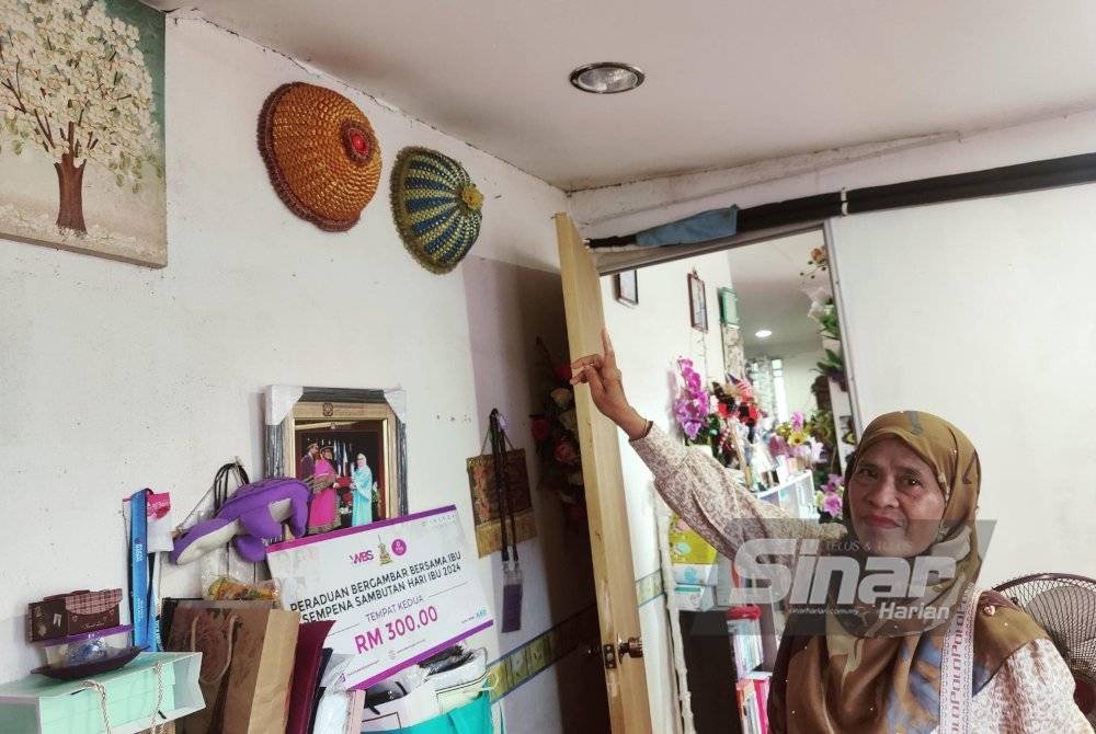 Latifah menunjukkan kesan retakan pada dinding rumahnya di Taman Ria, Sekinchan yang rosak akibat dibadai ribut.