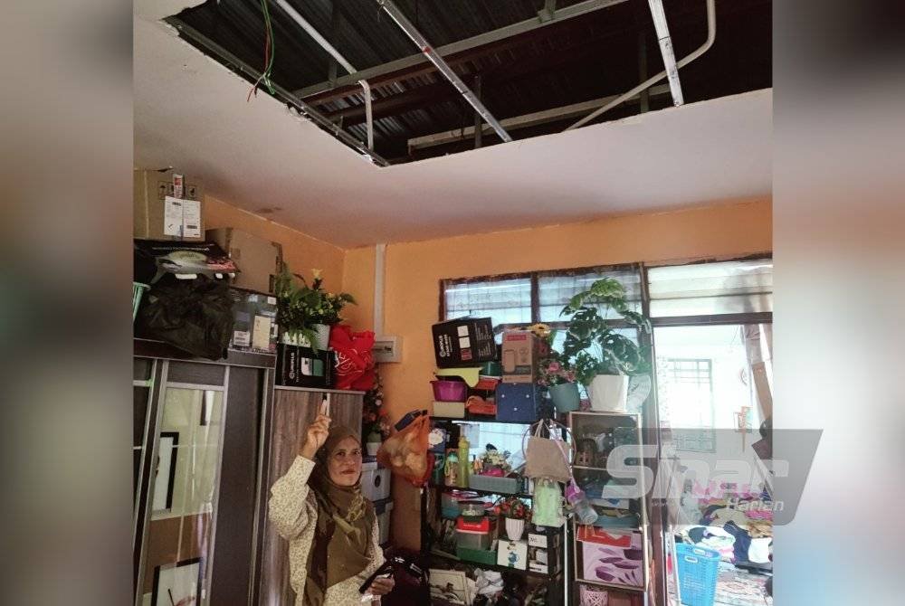 Latifah menunjukkan siling rumahnya yang runtuh akibat dibadai ribut di Taman Ria, Sekinchan.