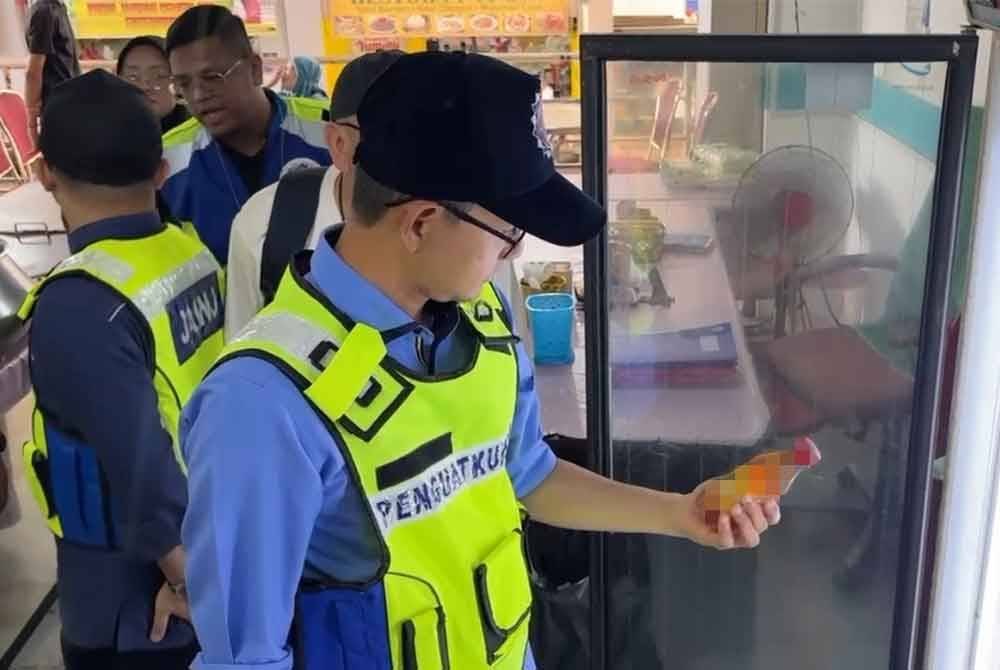 Mohd Fared memeriksa barangan yang dijual di premis berkenaan.