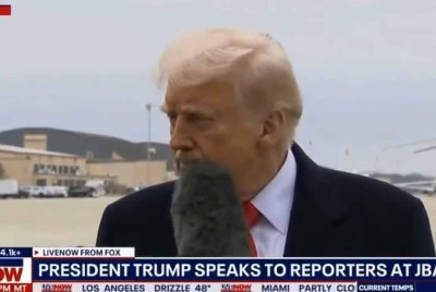 Mikrofon yang dipegang seorang wartawan wanita dilihat terkena pada muka Trump semasa sesi temu bual di Joint Base Andrews.