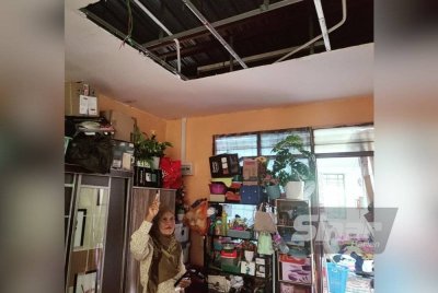 Latifah menunjukkan siling rumahnya yang runtuh akibat dibadai ribut di Taman Ria, Sekinchan.
