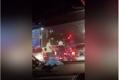 Tangkap layar video menunjukkan suspek (kiri) turun dari kenderaannya lalu memukul kepala seorang penunggang motosikal di persimpangan Kota Syah Bandar, Melaka pada awal pagi Sabtu.